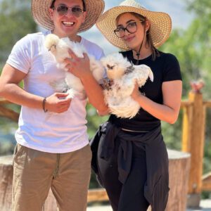 couple holding chickens at a ranch